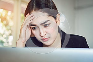 Business women sit and strain the computer screen for a long time. Because the work has been overloaded.