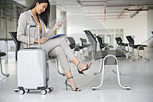 Business women sit and wait at passenger boarding terminal in airport