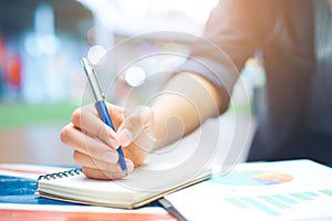 Business women take notes on business statistics and graphs. photo