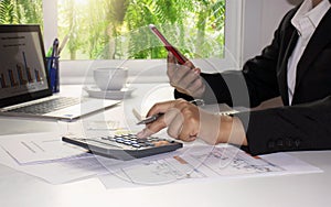 Business women use calculators to calculate annual reports.