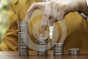 à¸µBusiness women use finger pace coins on stack of coins use for money financial banking concept