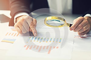 business women using magnifying to review financial report