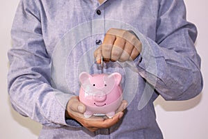 Business women who put coins in a piggy bank.