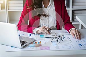 Business women working with calculator, business document and laptop computer notebook.