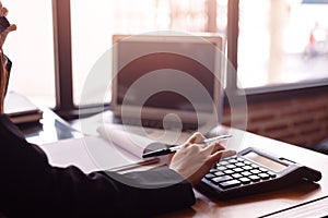 Business women  working with calculator and  business document on office table in office. finance accounting concept