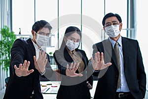 Business workers wear masks to protect and take care of their health.group asia business doing stop sing with palm of the hand