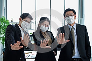 Business workers wear masks to protect and take care of their health.group asia business doing stop sing with palm of the hand