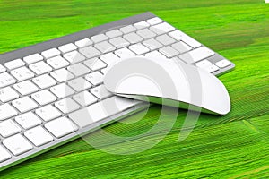 Business workplace with computer, wireless keyboard, keys and mouse on old green wooden table background. Office desk with copy