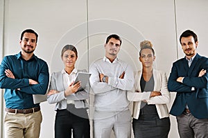 The business world better be ready for us. Portrait of a group of businesspeople standing in an office.