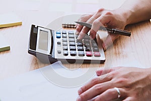 Business young man hand using calculator Calculating bonusOr other compensation to employees to increase productivity.Writing