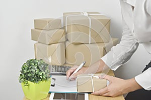 Business young woman holding clipboard with pen checking order product and prepare product for delivery to customer