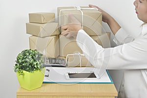 Business young woman holding clipboard with pen checking order product and prepare product for delivery to customer