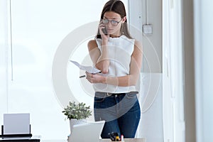 Business young woman using her mobile phone in the office.