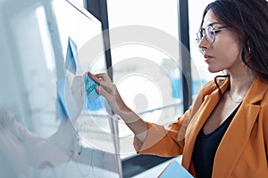 Business young woman working on white board with post it stickers in the office