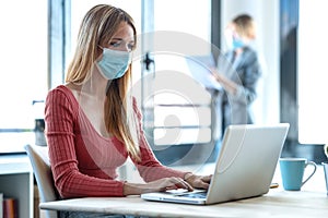 Business young women wearing a hygienic facial mask working in the office while keeping safe distances
