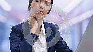 Businesslady suffering strong pain in neck and massaging, sedentary lifestyle