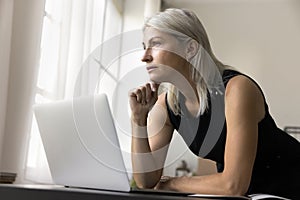 Businesslady work on laptop, looking away, think about new project