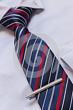 Businessman accessories. Man shirt with blue tie and silver tie clip close-up