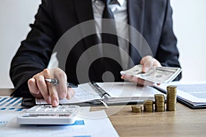 Businessman accountant counting money and making notes at report doing finances and calculate about cost of investment and