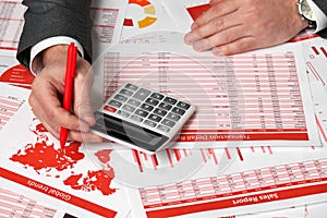 Businessman accountant using calculator for calculating finance on desk office. Business financial accounting concept Red reports