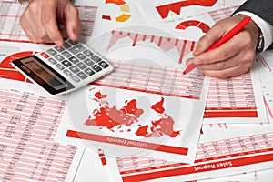 Businessman accountant using calculator for calculating finance on desk office. Business financial accounting concept Red reports