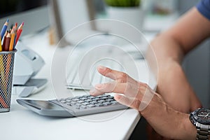 Businessman accountant using calculator and desktop for calculating finance on desk office closeup. Business financial