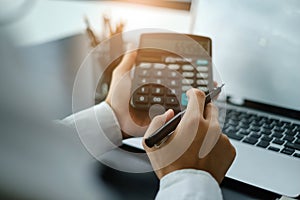 Businessman accountant using calculator. Stressed young man checking bank account balance, bills, taxes and calculating