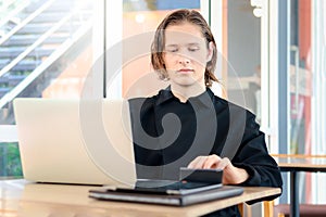 Businessman or accountant young handsome man using laptop computer and calculator to calculate financial data, cost and budget on