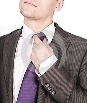 Businessman adjusting his tie against white