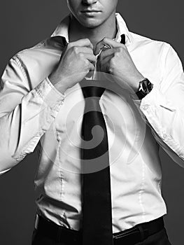 Businessman adjusting his tie. black and white