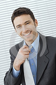 Businessman adjusting tie