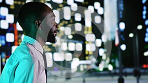 Businessman admires skyscrapers at night