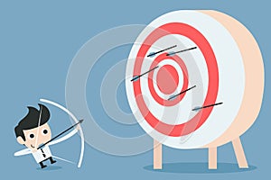 Businessman aiming at target with bow and arrow photo