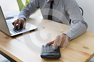 Businessman Analyzing financial data on computer and counting on