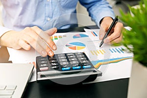 Businessman analyzing financial graphs and reports