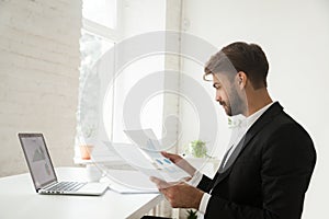 Businessman analyzing financial project statistics report satisf