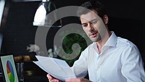 Businessman analyzing financial reports at workplace. Man working on laptop