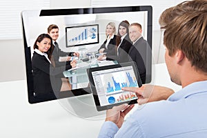 Businessman analyzing graphs while video conferencing