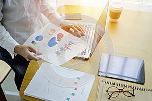 Businessman analyzing investment charts with laptop