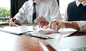 Businessman analyzing investment charts and pressing calculator buttons over documents. Accounting Concept