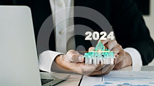 Businessman analyzing the profitability or cost of a working company 2024 with hands pointing at a higher target