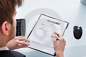 Businessman analyzing resume at office desk