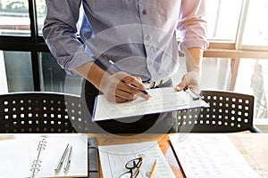 Businessman analyzing a series of graphs with colleagues while meeting summaries of sales and holding a map with statistics in photo