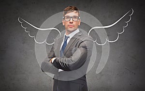 Businessman with angel wings over gray