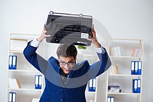 The businessman angry at copying machine jamming papers photo