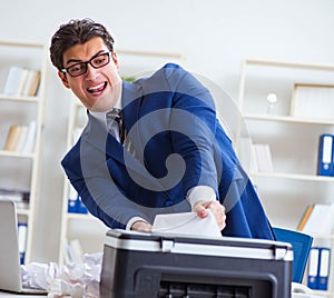 Businessman angry at copying machine jamming papers