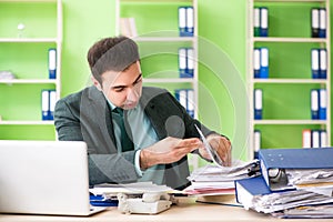 The businessman angry with excessive work sitting in the office