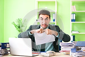 The businessman angry with excessive work sitting in the office