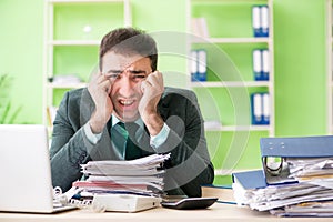 The businessman angry with excessive work sitting in the office