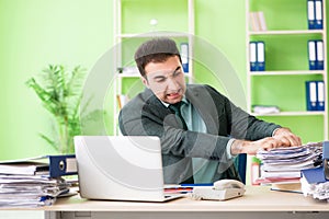 The businessman angry with excessive work sitting in the office